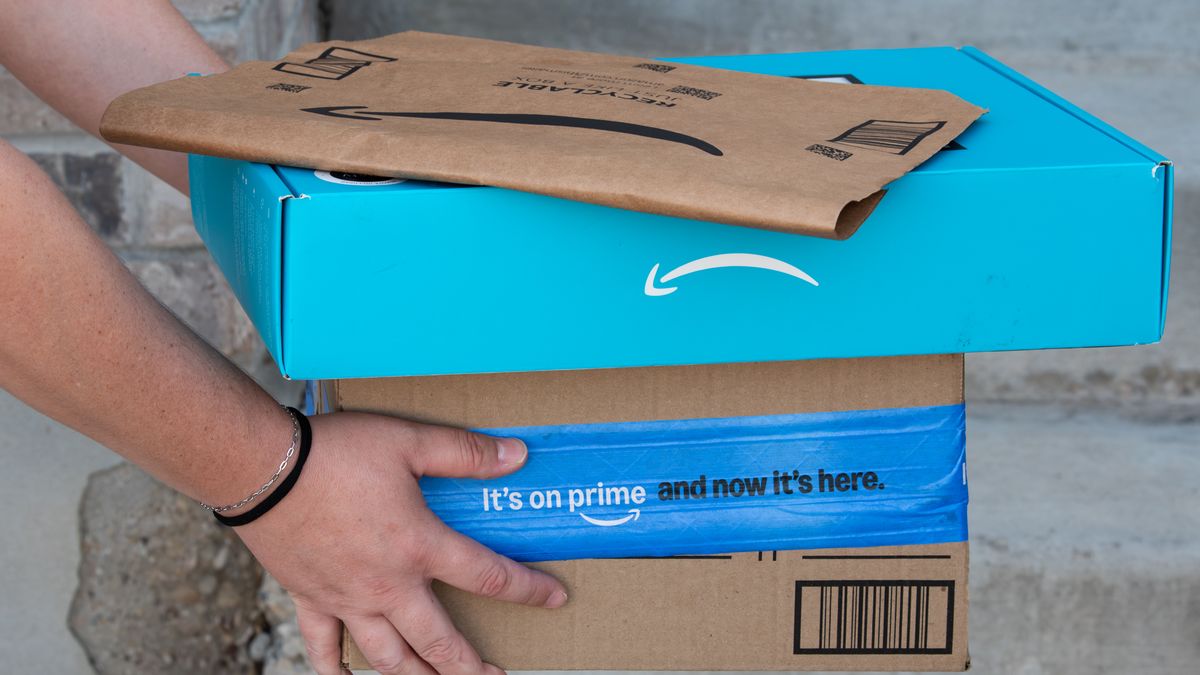 A person holds a stacked pile of Amazon cardboard boxes and shipping envelopes on residential steps in Saratoga Springs, Utah, United States, on August 31, 2026. (Photo by Charles-McClintock Wilson/NurPhoto via Getty Images)