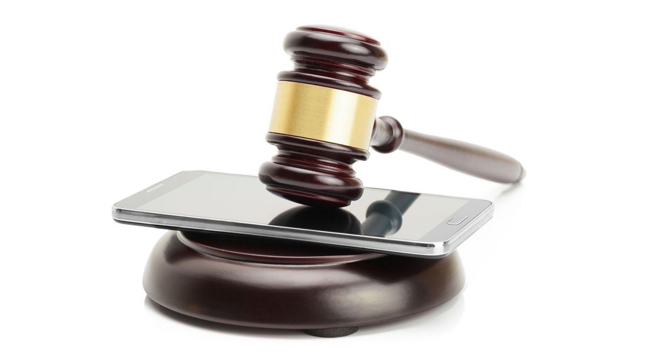 Smartphone between judge gavel and soundboard