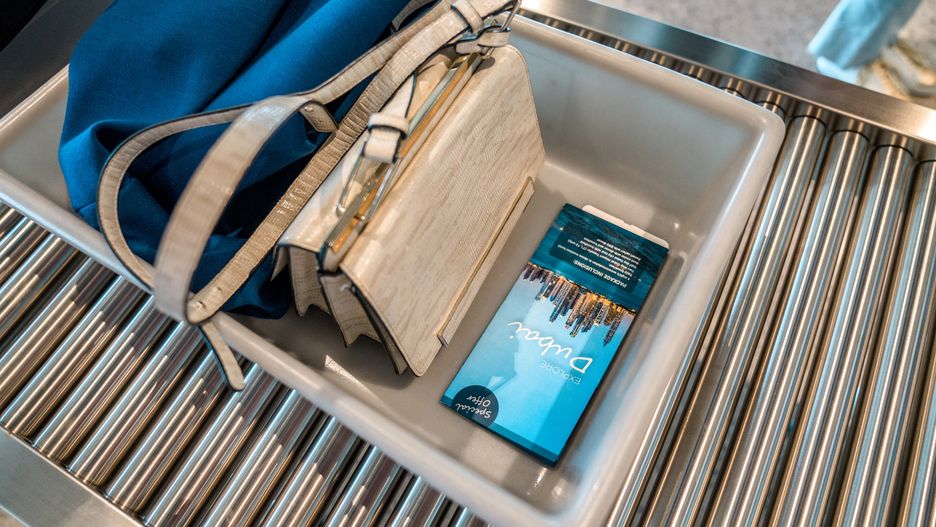 Lady's Hand Luggage  on Plastic Tray Going to Baggage Screening
A woman's purse, a book and a jacket on a plastic tray moving along a roller conveyor at the airport security check and baggage screening machine. 3/4 length image.
AzmanL