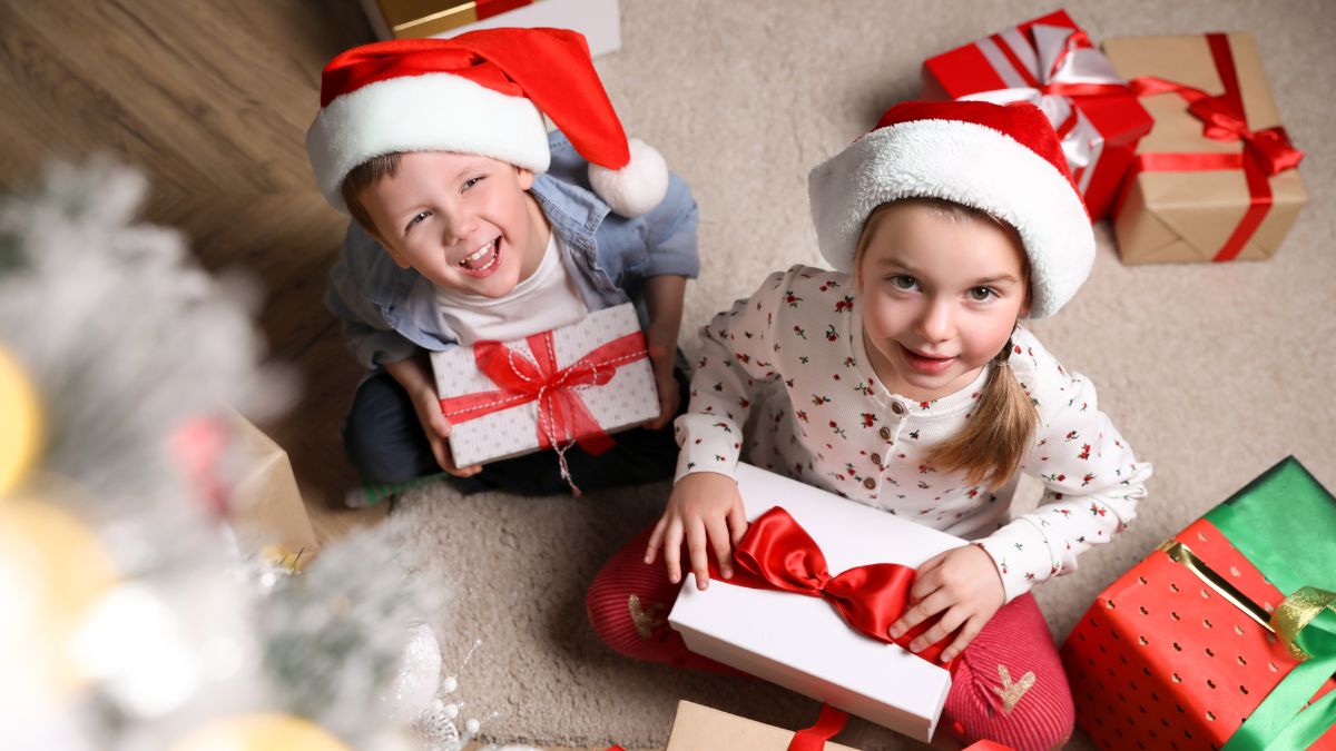 Dzieci otwierają prezenty świąteczne.
