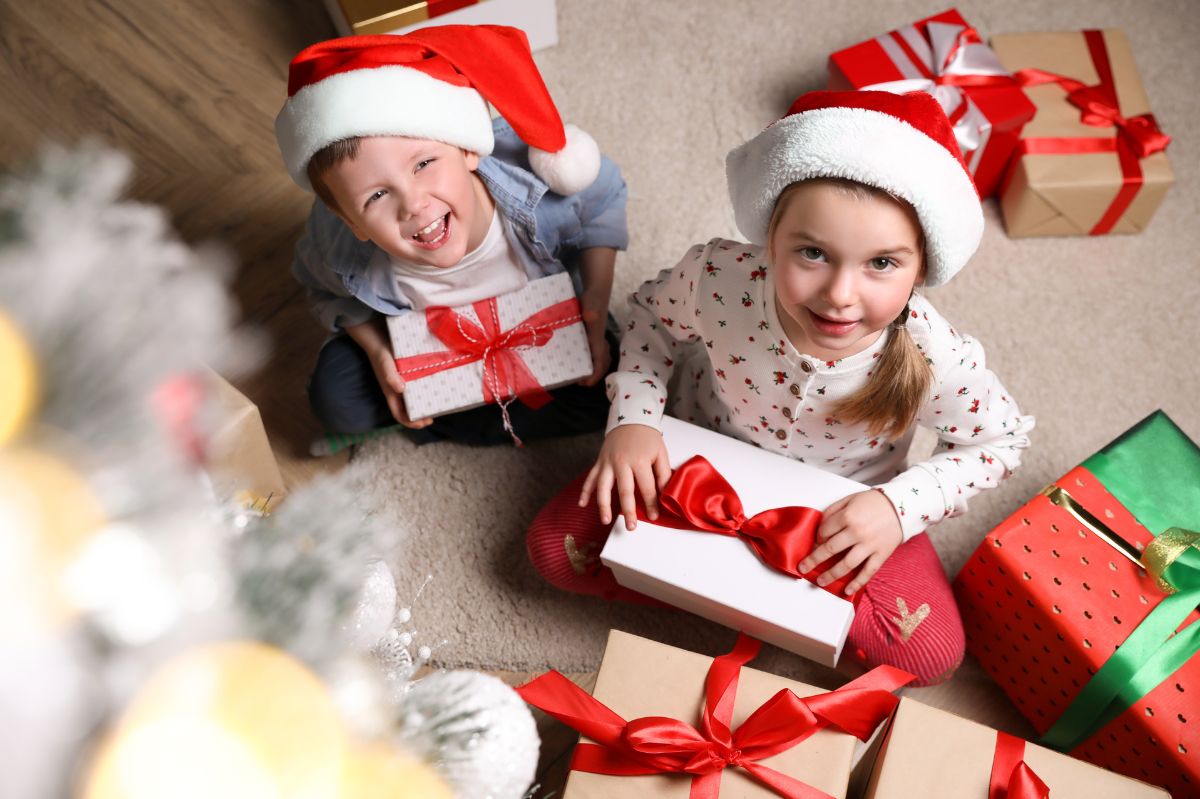 Dzieci otwierają prezenty świąteczne.