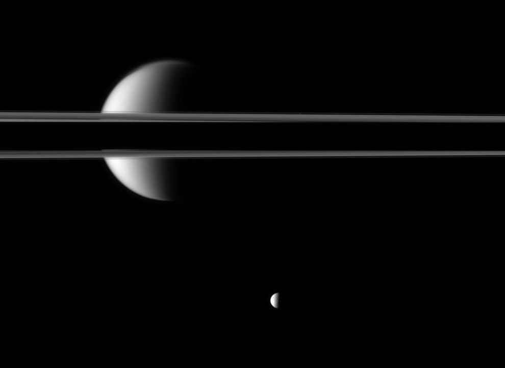 Pierścienie Saturna, częściowo przykryte cieniem rzucanym przez gazowego olbrzyma, zdają się przecinać na pół jego księżyc, Tytana. Sama planeta znajduje się poza lewą krawędzią zdjęcia. Całej scenie "przygląda się" mniejszy Mimas. Wprawne oko dostrzeże jeszcze malutką plamkę na prawo od Tytana, w cienkiej szparze przy górnej krawędzi pierścieni to księżyc Atlas o średnicy zaledwie 30 km.