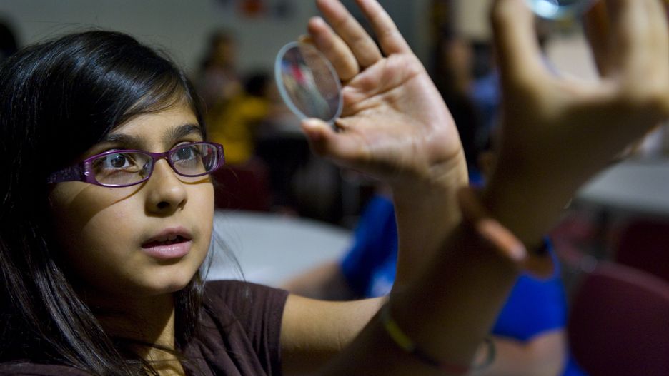 GREENBELT, MD  - JULY 25:  (L-R)  Rebecca Stevenson, 11, of Montgomery Village uses to different types of lenses to see what's happening inside a telescope at Goddard Space Flight Center in Greenbelt, MD on Wednesday, July 25, 2012.  It's all part of Family Science Night where kids and their parents learn about science and engineering and do hands-on projects.  This evening they learned about the James Webb telescope, how it works then made telescopes to take home.  Near dusk the kids were able to look at 