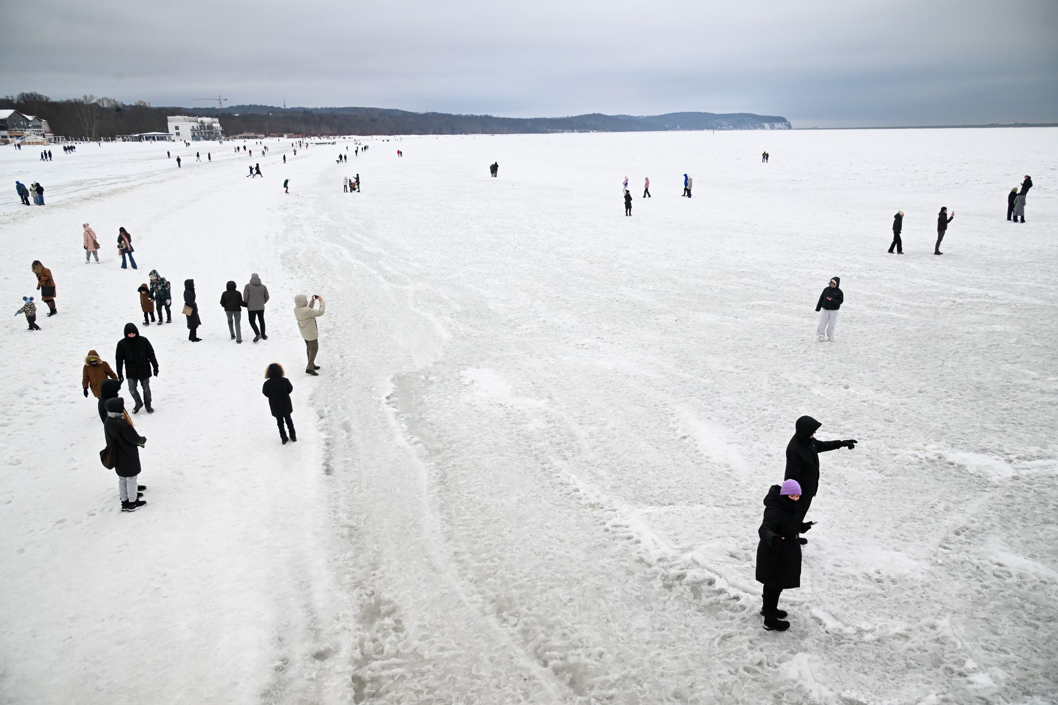 Sopot, 08.02.2026. Skuty lodem Bałtyk w Sopocie, 8 bm. Morze Bałtyckie zamarzło przy linii brzegowej. Mimo ostrzeżeń straży miejskiej, mieszkańcy i turyści spacerują po lodowej tafli. (aldg) PAP/Andrzej Jackowski