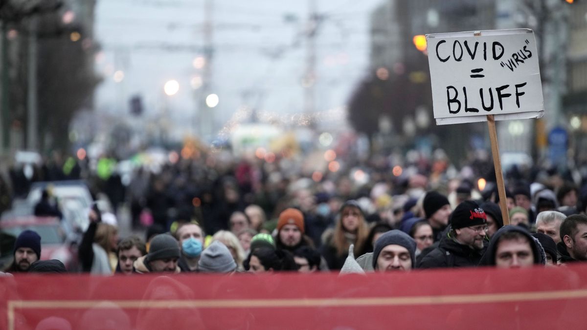 Na zdjęciu tłum demonstrantów w Sztokholmie. Wyraźnie widać tabliczkę z napisem "covid 'virus' = bluff".