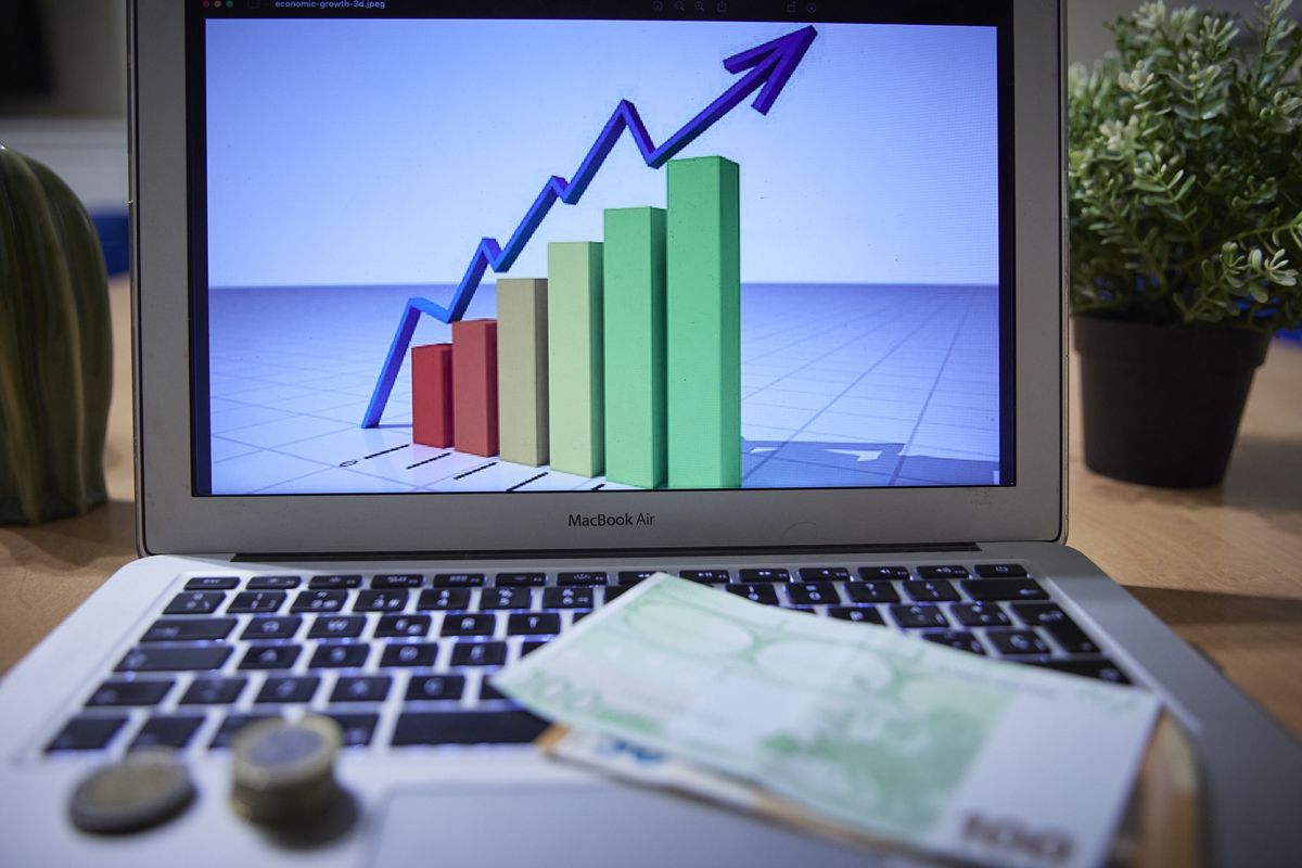 MADRID, SPAIN - JANUARY 04: A chart on a laptop computer with banknotes and coins, on 4 January 2022, in Madrid, Spain. The General Council of Economists estimates that the Spanish economy will grow by 5.6% in 2022. It also warns of the dangers of the rebound in the Consumer Price Index (CPI) and the rise in core inflation. (Photo By Jesus Hellin/Europa Press via Getty Images)