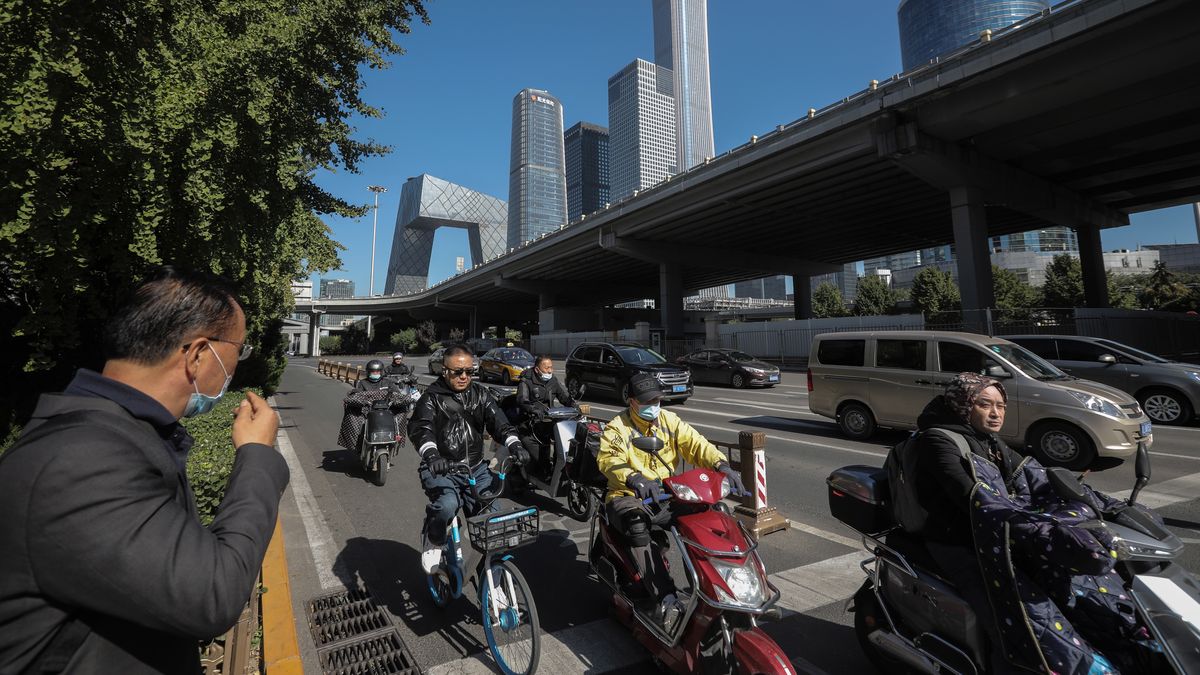 epa09529482 People ride bicycles and scooters in the central business district (CBD) in Beijing, China, 17 October 2021 (issued 18 October 2021). China's gross domestic product (GDP) rose 4.9 percent year on year in the third quarter of 2021, according to data from the National Bureau of Statistics (NBS) issued on 18 October 2021.  EPA/WU HONG Dostawca: PAP/EPA.