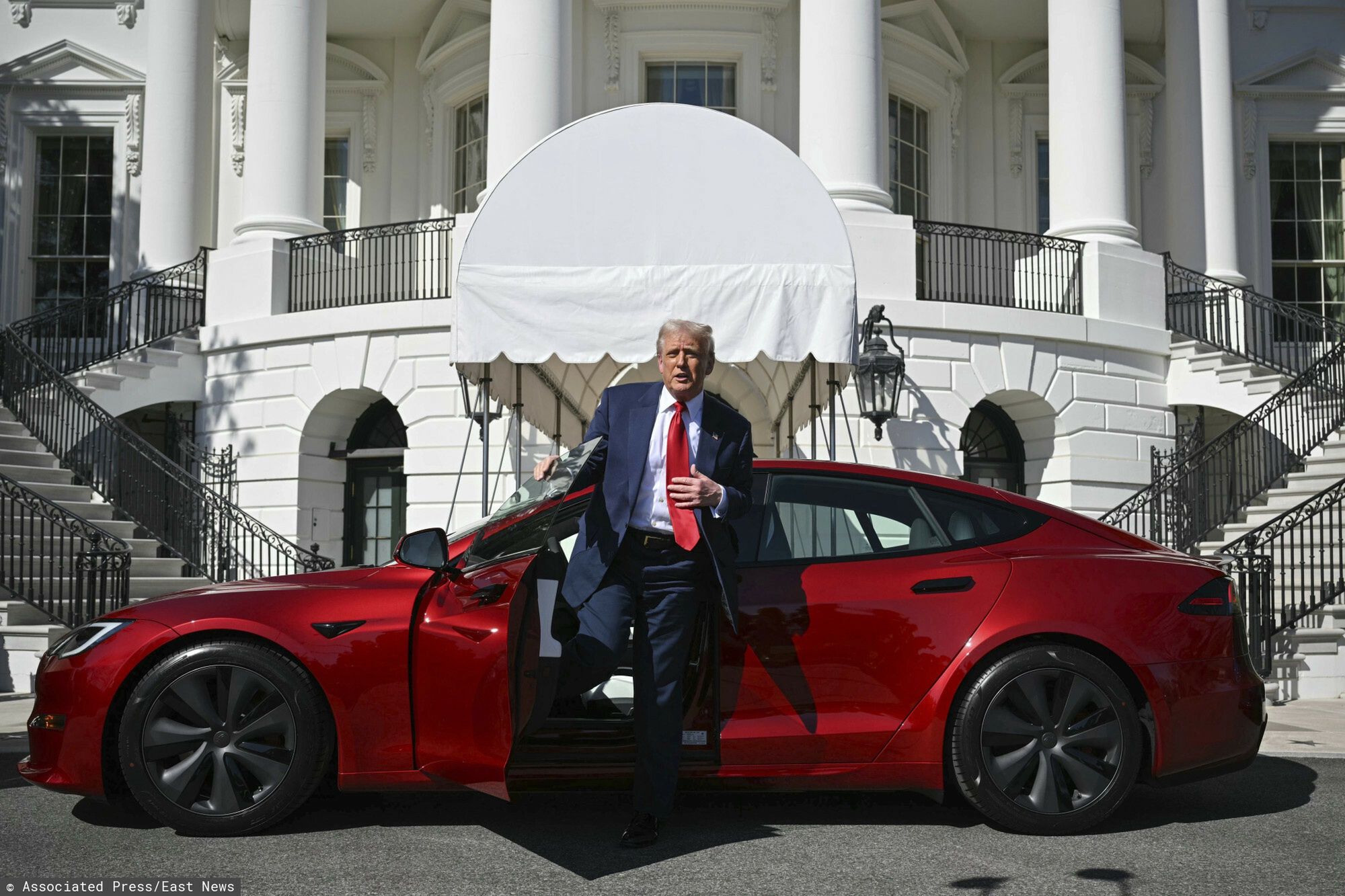 Prezydent Trump kupuje Tesl?
President Donald Trump steps out of a red Model S Tesla vehicle on the South Lawn of the White House Tuesday, March 11, 2025, in Washington. (Pool via AP)