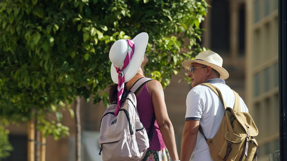 MALAGA ANDALUSIA, SPAIN - JULY 18: Two people wearing summer clothes and hats.18 July 2025, in Malaga (Andalusia, Spain). Andalusia faces a new day of intense heat, although the temperature begins to subside in the community. For this Friday, only the province of Malaga will remain under orange warning, while the rest of Andalusia will maintain active yellow warnings, except Cadiz and Huelva, with maximum temperatures that will reach 39 degrees. (Photo By Alex Zea/Europa Press via Getty Images)