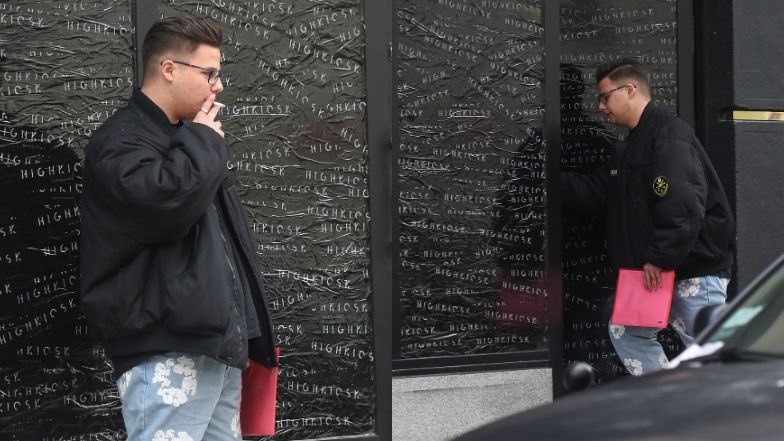 Allan Krupa pali papierosa przed butikiem