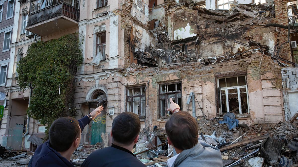 KYIV, UKRAINE - 2022/10/18: People look at the residential building destroyed by a Russian drone strike, which local authorities consider to be Iranian-made unmanned aerial vehicles (UAVs) Shahed-136, in central Kyiv. At least four people have been killed as a result of a drone attack on a residential building in Kyiv on the morning of October 17, 2022. (Photo by Oleksii Chumachenko/SOPA Images/LightRocket via Getty Images)