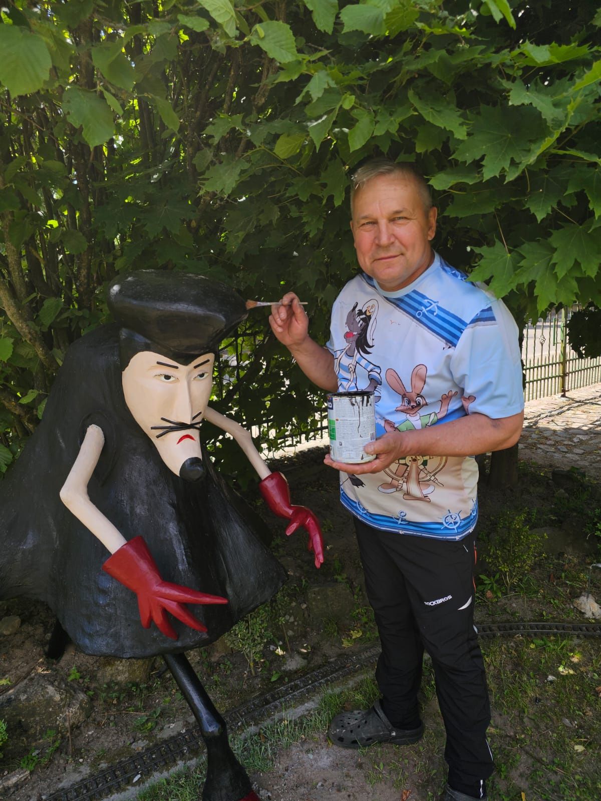Tadeusz Żyła z Czarnego przy drewnianej rzeźbie w swoim ogrodzie