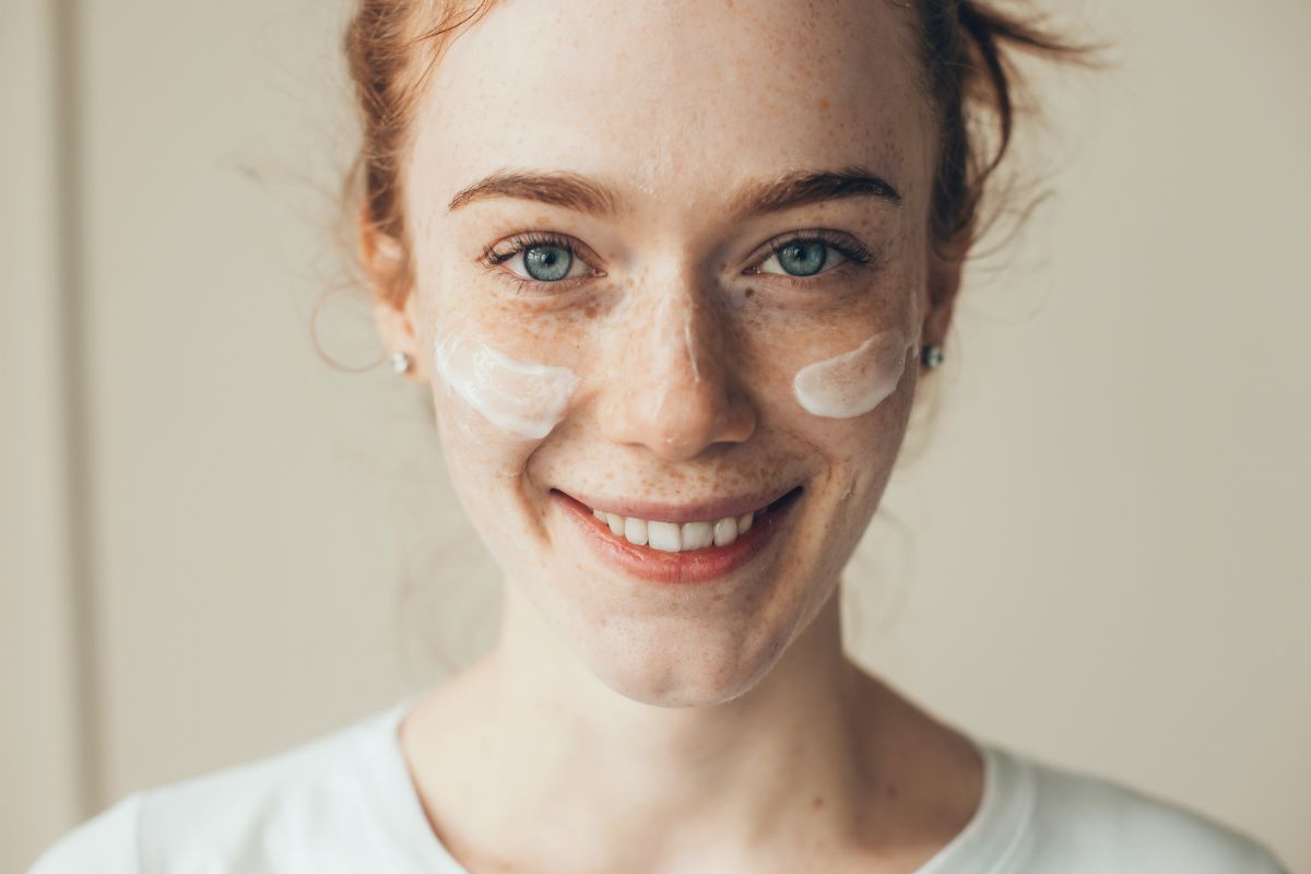 Applying sunscreen cream to the face