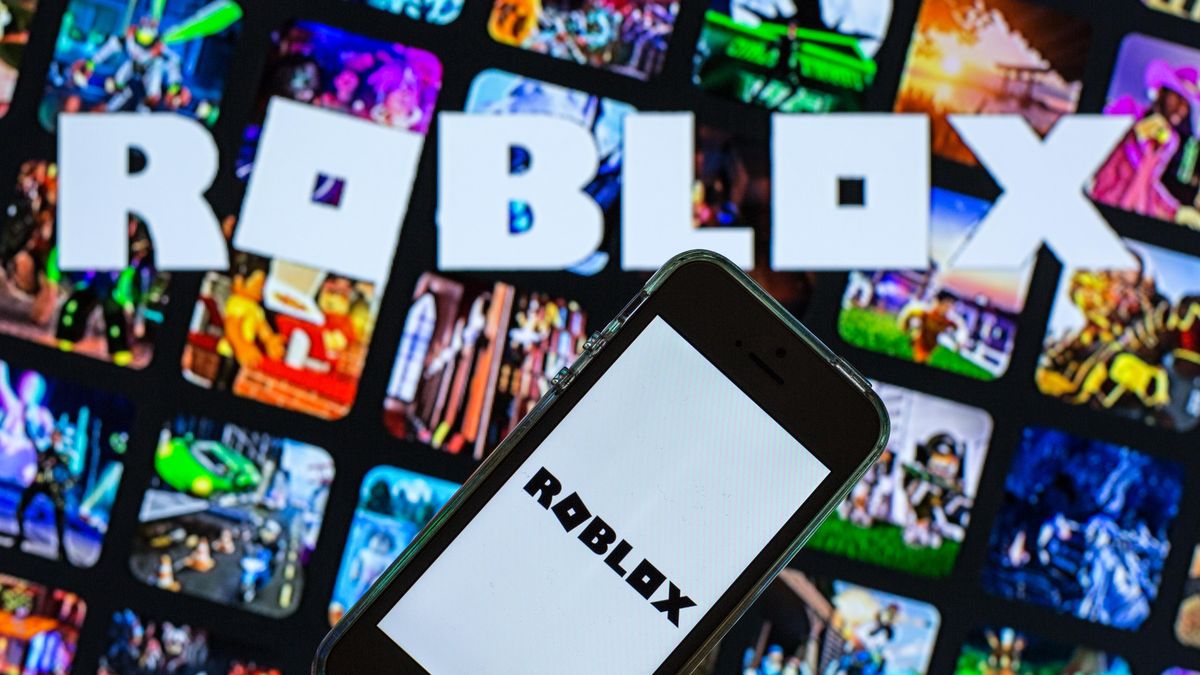 SPAIN - 2021/03/30: In this photo illustration, the Roblox app seen displayed on a smartphone screen and a Roblox logo in the background. (Photo Illustration by Thiago Prudêncio/SOPA Images/LightRocket via Getty Images)