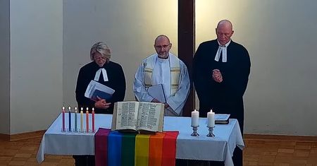 Na ołtarzu tęczowa flaga i świeczki. Ksiądz błogosławił parom LGBT+