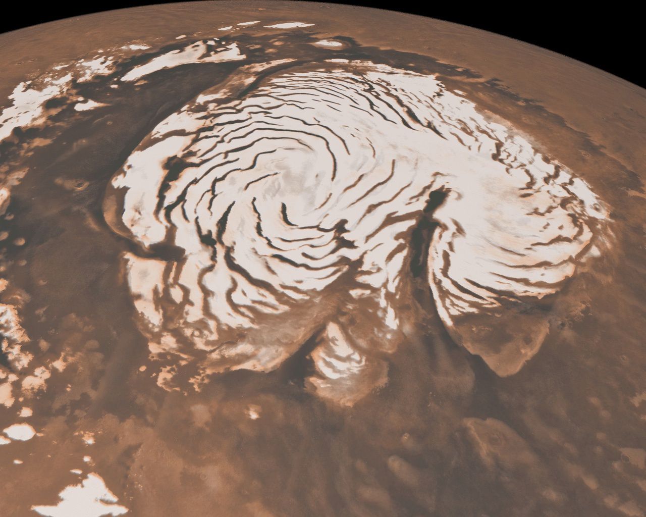 Północna pokrywa lodowa Marsa. To zdjęcie, łączące dane z dwóch instrumentów znajdujących się na pokładzie Mars Global Surveyor NASA, przedstawia orbitalny widok północnego bieguna Marsa. Bogata w lód czapa polarna ma średnicę około 1000 kilometrów. Biała czapa jest poprzecinana ciemnymi, spiralnymi paskami. Są to głębokie doliny, które są w cieniu. Nie odbijają tak dobrze światła słonecznego lub mają więcej odsłoniętych warstw wewnętrznych. Na prawo od środka duży kanion, Chasma Boreale, prawie przecina czapę lodową na pół. Chasma Boreale ma mniej więcej długość słynnego Wielkiego Kanionu w Stanach Zjednoczonych i ma głębokość do 2 kilometrów. Obraz stanowi syntezę danych topograficznych z wysokościomierza laserowego orbitera marsjańskiego oraz obrazów z kamery orbitera marsjańskiego