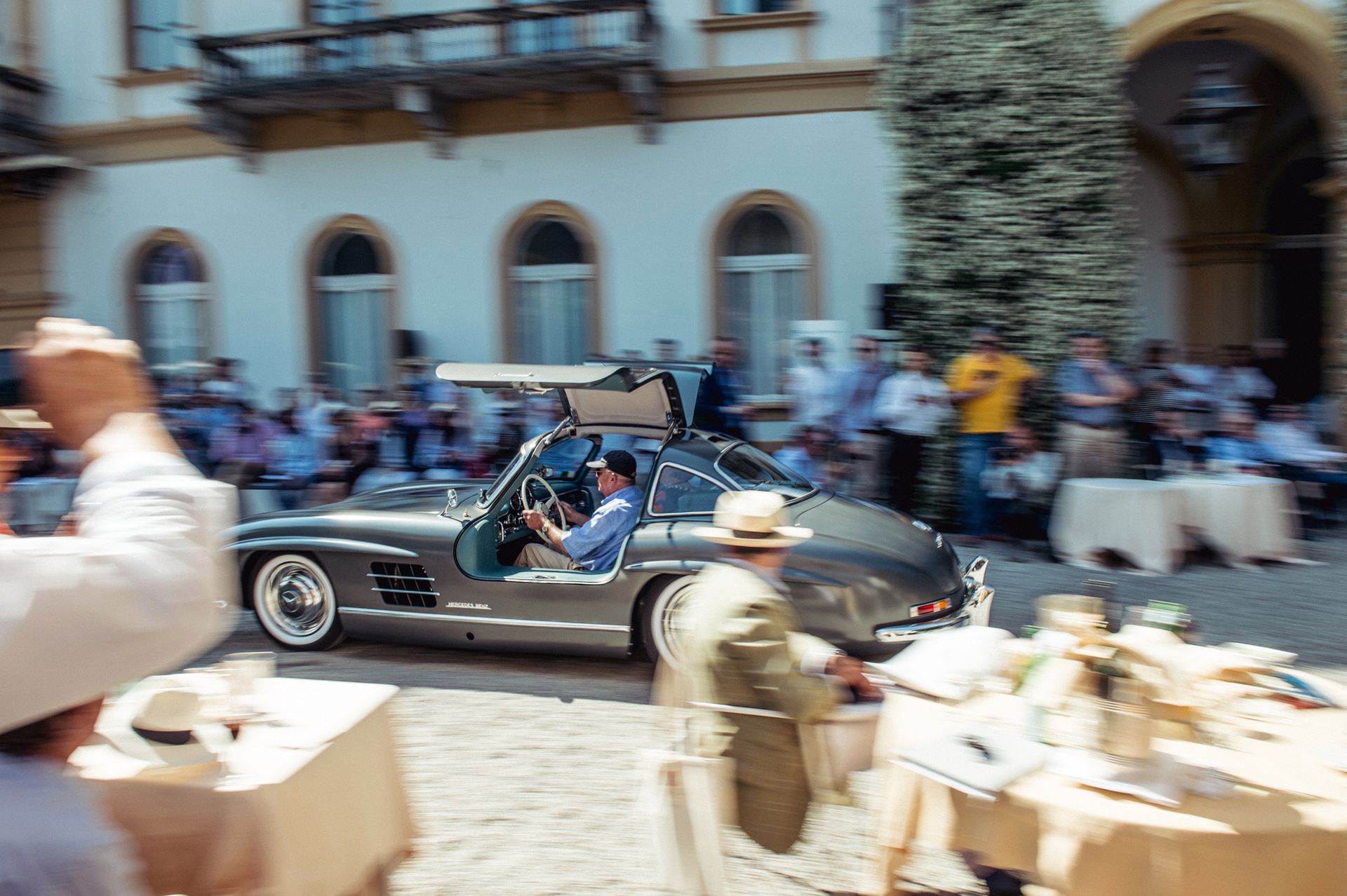 Mercedes-Benz 300SL Gullwing, niegdyś należący Dr.Schneidera, mija widzów z podniesionymi drzwiami. W Gullwingu nie otwierają się bowiem okna.