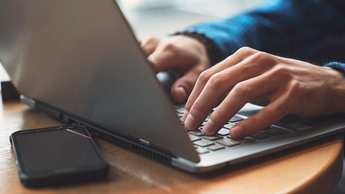 Człowiek piszący na laptopie z depositphotos