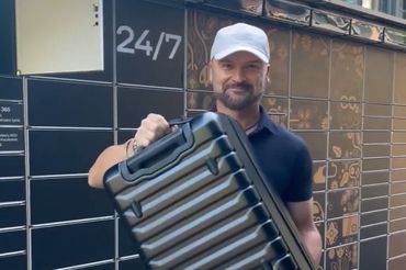 Rafał Brzoska z walizką oferowaną przez InPost