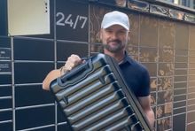 Rafał Brzoska z walizką oferowaną przez InPost