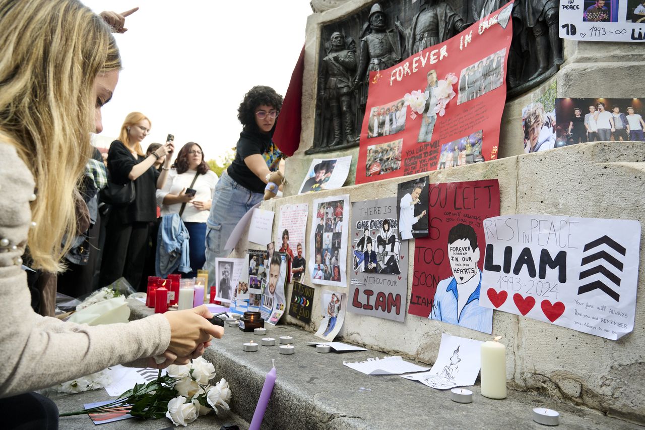 MADRID, SPAIN - OCTOBER 20: Flowers, photos and candles are displayed in honor of Liam Payne during a memorial gathering at Santa Ana Square on October 20, 2024 in Madrid, Spain. According to the Buenos Aires police department, Payne fell from a third-floor hotel room balcony in Palermo, a famous neighborhood in Buenos Aires. Fans around the city gather to pay tribute to the former member of boy band One Direction. (Photo by Borja B. Hojas/Getty Images)