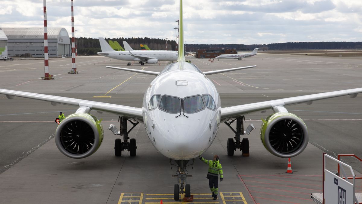 A member of ground crew inspects an Airbus A220-300 passenger aircraft, operated by Air Baltic Corp AS, at Riga International Airport in Riga, Latvia, on Tuesday, March 28, 2023. The summer travel season is shaping up to be a good one for European airlines, prompting Deutsche Bank AG and Barclays Plc to upgrade several carriers that could benefit from rising fares, strong demand and lower jet fuel prices. Photographer: Andrey Rudakov/Bloomberg via Getty Images
