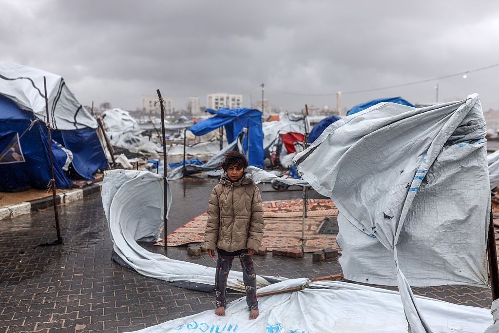 Palestyńska dziewczynka przed zniszczonym rodzinnym namiotem