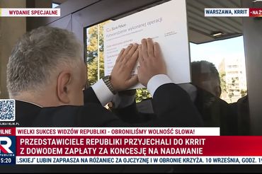 Tomasz Sakiewicz przykleja kopię przelewu