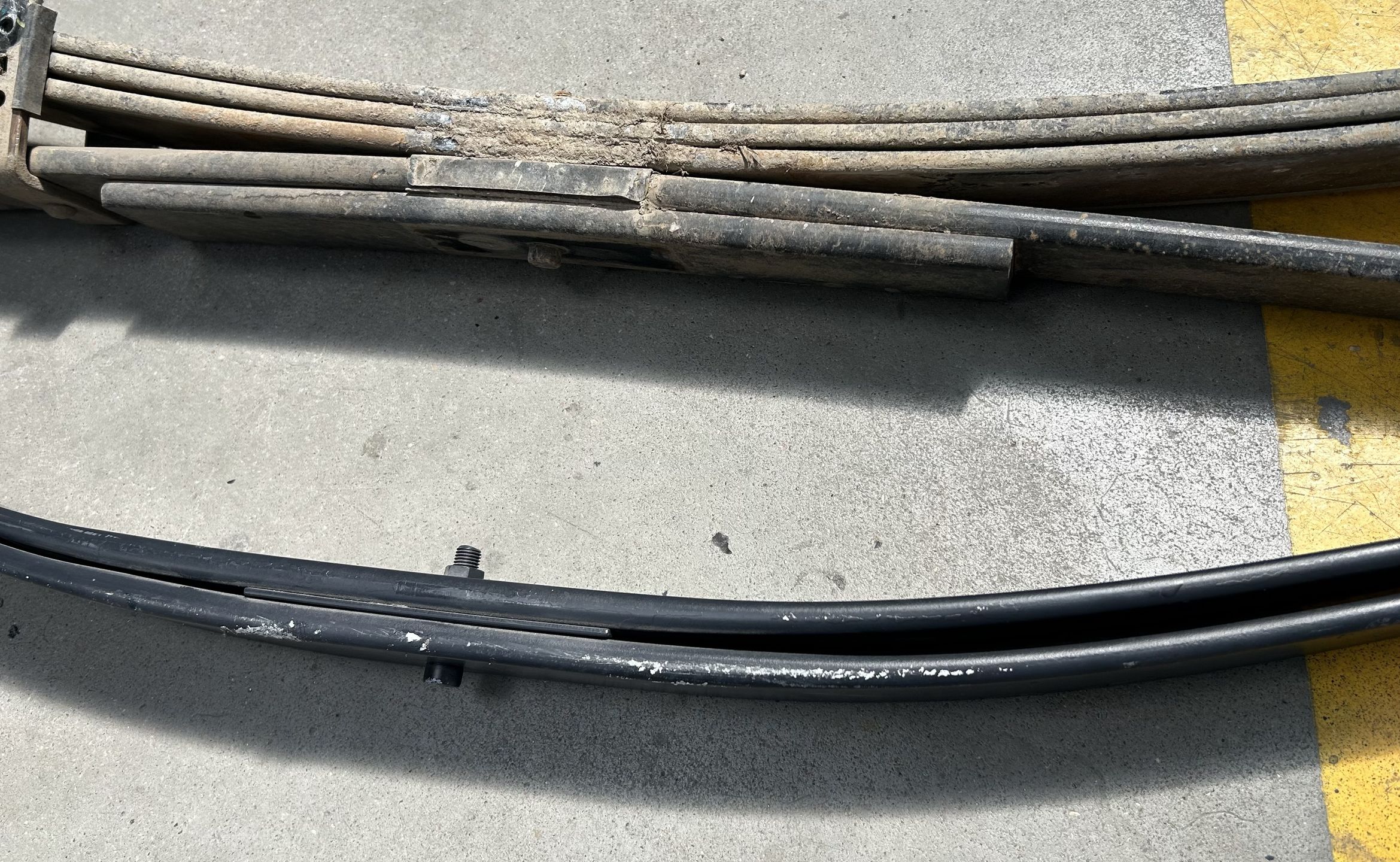Wyżej standardowy resor Toyoty Hilux, niżej paraboliczny. Różnicę widać gołym okiem. 