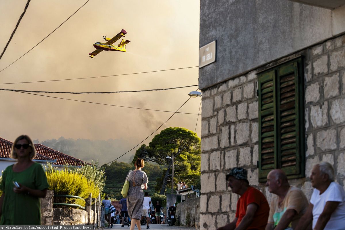 Samolot gaśniczy rozpyla wodę, aby ugasić pożar na wyspie Ciovo w Chorwacji