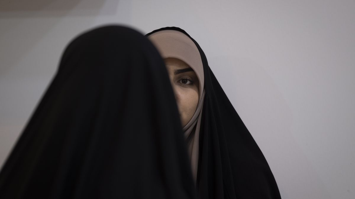 Two veiled Iranian women are speaking with each other at the Hijab and Chastity fair in the Imam Khomeini Grand Mosque in downtown Tehran, Iran, on March 28, 2024. Amir Hossein Bankipour, a Member of the Iranian Parliament from Isfahan and a member of the Cultural Commission, is saying on the ''Ofogh TV program'' that after the Nowruz holidays, women who do not wear a hijab will not be fined by the police; instead, 30,000,000 Rials (49 USD) will be automatically deducted from their personal bank accounts. (Photo by Morteza Nikoubazl/NurPhoto via Getty Images)