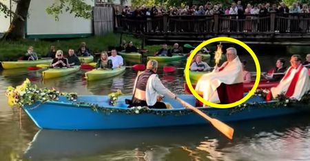 Sceny w Zwierzyńcu. Ksiądz w łodzi, za nim wierni