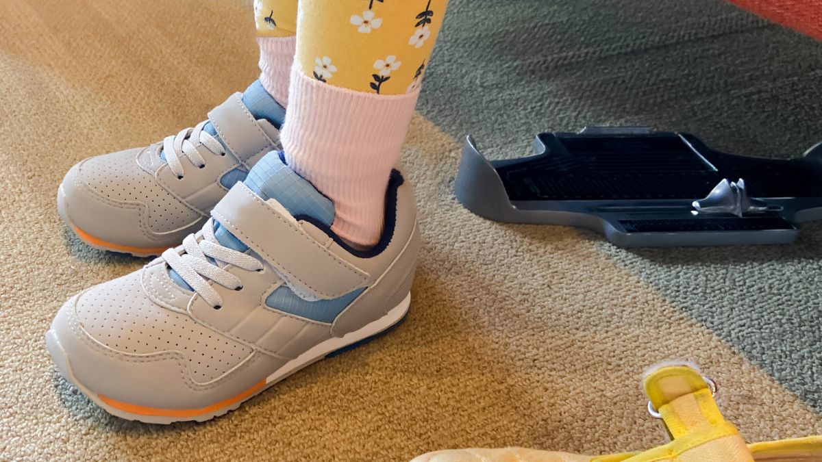 Dziecko stoi w butach na dywanie