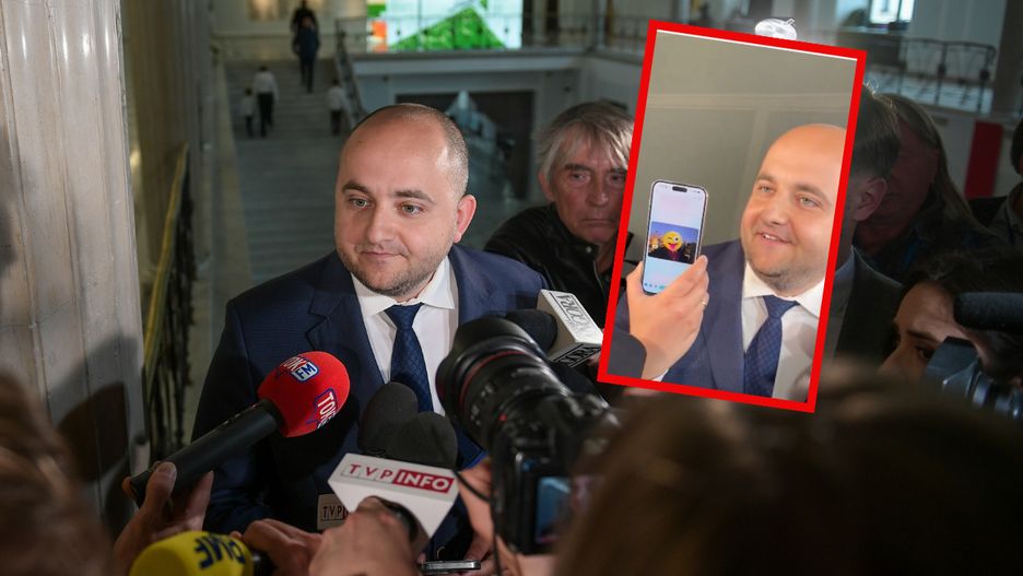 Poseł Dariusz Matecki pokazuje dziennikarzom zdjęcie, które zrobił na dachu Sejmu