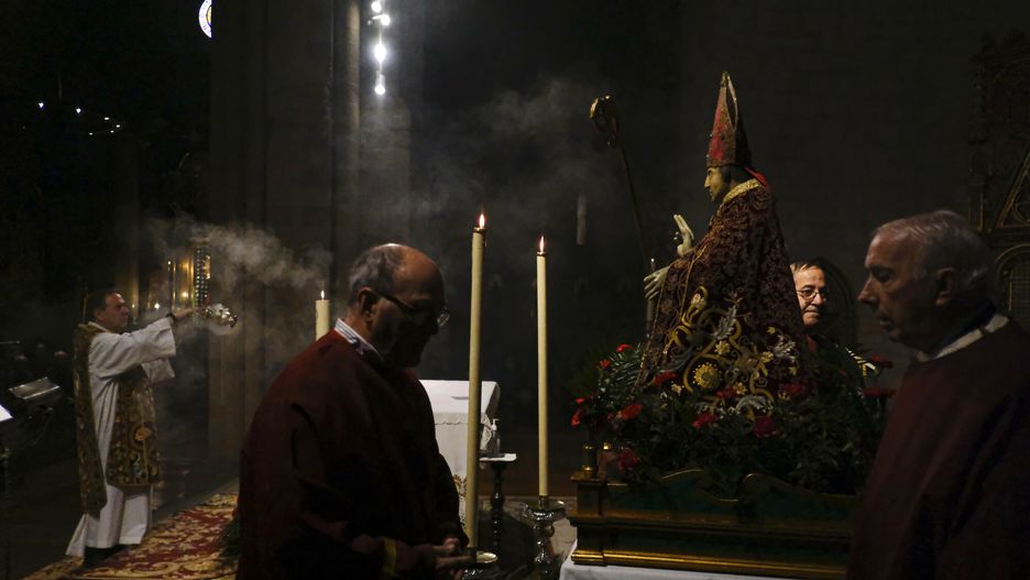 Ksiądz błogosławi posąg św. Blasa w kościele św. Mikołaja w północnej Hiszpanii