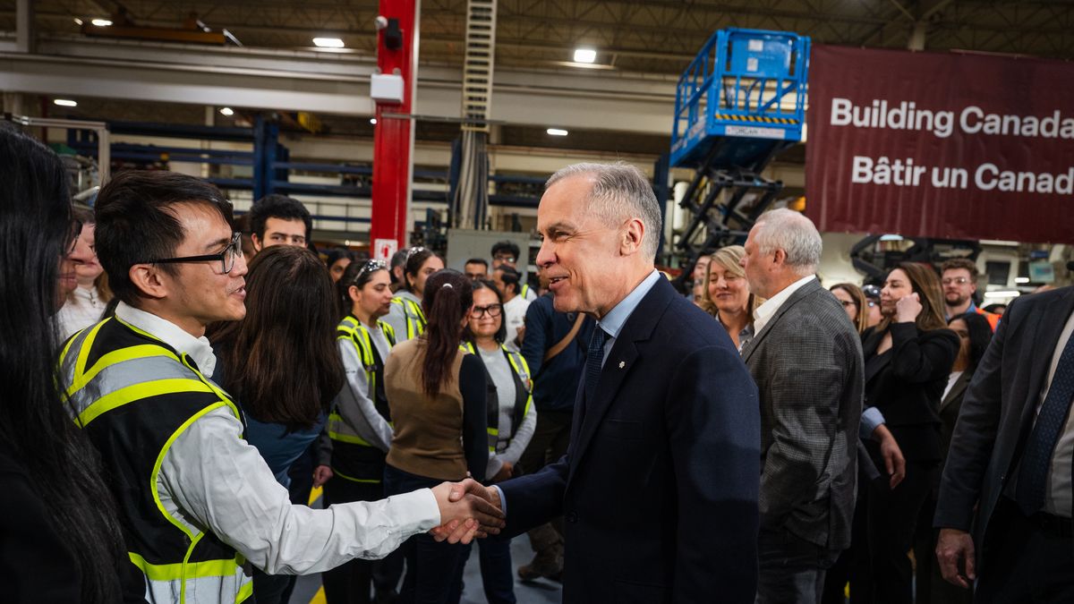 Mark Carney, Canada's prime minister, right, greets workers after a news conference at a Martinrea auto parts manufacturing facility in Woodbridge, Ontario, Canada, on Thursday, Feb. 5, 2026. Prime Minister Mark Carney's government plans to change its tariff system to create a stronger financial incentive for automakers to invest in Canada, resisting US efforts to lure factory jobs away. Photographer: Laura Proctor/Bloomberg via Getty Images