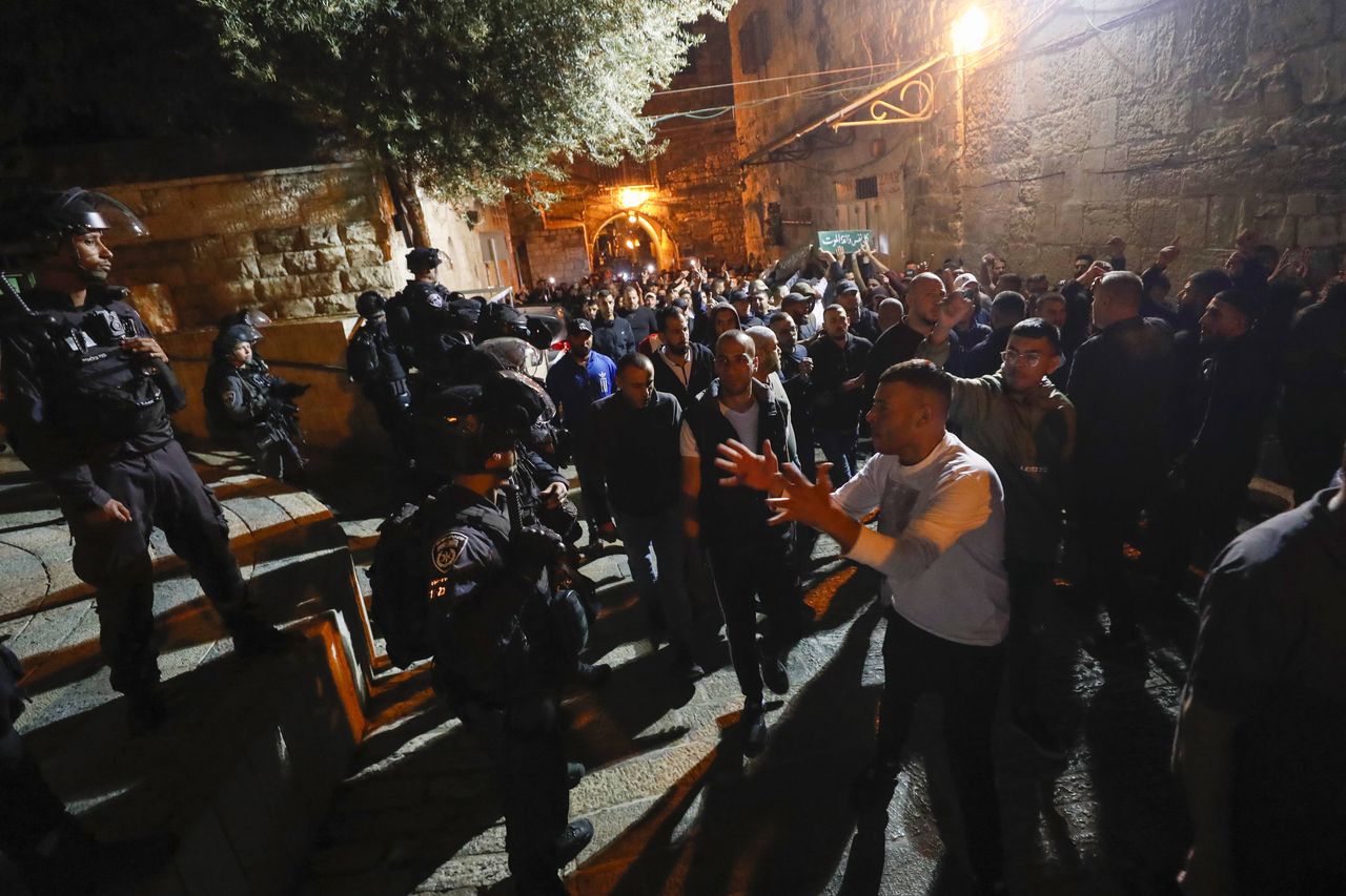 Palestyńscy żałobnicy i izraelscy policjanci podczas pogrzebu Walida al-Szarifa, 16.05.2022 r. Al-Szarif zginął od rany w głowę podczas starć pod meczetem Al-Aksa 