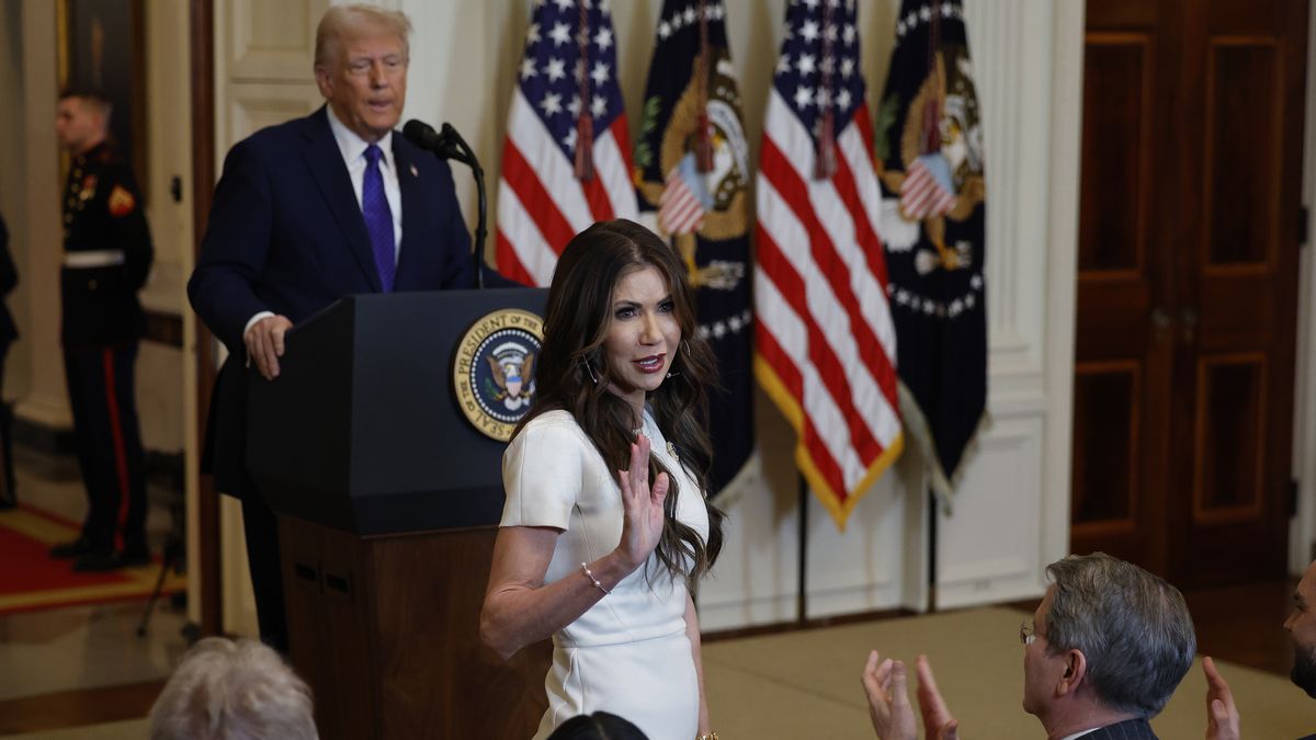 WASHINGTON, DC - JANUARY 29: Homeland Security Secretary Kristi Noem stands while being acknowledged by U.S. President Donald Trump during the signing ceremony for the Laken Riley Act in the East Room of the White House on January 29, 2025 in Washington, DC. Jason Riley and Allyson Philips, the parents of 22-year-old Laken Riley, a University of Georgia nursing student who was murdered in 2024 by an undocumented immigrant, attended the signing ceremony. Among other measures, the law directs law enforcement authorities to detain and deport immigrants who are accused but not yet convicted of specific crimes, if they are in the country illegally.  (Photo by Chip Somodevilla/Getty Images)