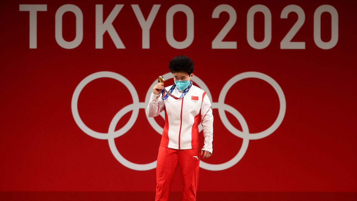 TOKYO, JAPAN - JULY 24: Gold medalist Zhihui Hou of Team China poses with the gold medal for the Weightlifting - Women's 49kg Group A on day one of the Tokyo 2020 Olympic Games at Tokyo International Forum on July 24, 2021 in Tokyo, Japan. (Photo by Chris Graythen/Getty Images)
