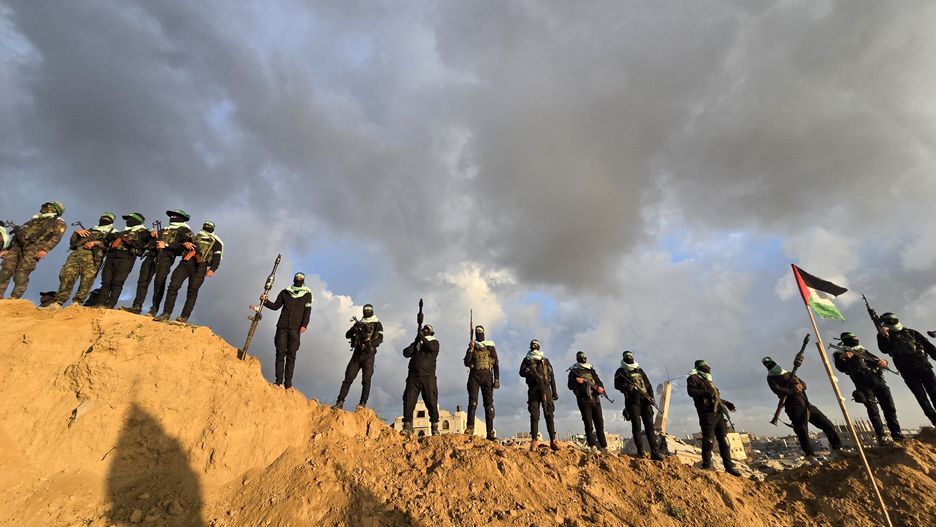 KHAN YUNIS, GAZA - FEBRUARY 20: Members of the Al-Qassam Brigades, the military wing of Hamas, take precautions around the cemetery in Bani Suheila municipality before the bodies of the Bibas family (three members) and Oded Lifshitz are handed over to the Red Cross teams as part of the Hamas-Israel prisoner-hostage swap agreement in Khan Yunis Governorate, Gaza on February 20, 2025. Al-Qassam Brigades announced that the four Israeli hostages were alive when captured, but the Israeli army killed them by deliberately bombing detention sites during the attacks in the Gaza Strip. (Photo by Ashraf Amra/Anadolu via Getty Images)