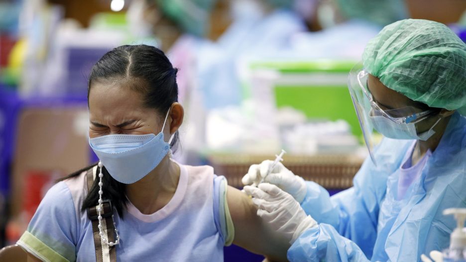 epa09252508 A Thai woman reacts as she receives a dose of AstraZeneca (Vaxzevria) vaccine during a mass vaccination against COVID-19 coronavirus pandemic at a gymnasium turned to non-hospital vaccination center in Bangkok, Thailand, 07 June 2021. Thailand rolled out the mass vaccinations across the country in an effort to contain the nationwide spread of COVID-19 coronavirus pandemic amid a shortage of jabs while thousands of infections and surging death tolls have been reported daily. Bangkok has the highest number of infections in Thailand.  EPA/RUNGROJ YONGRIT Dostawca: PAP/EPA.