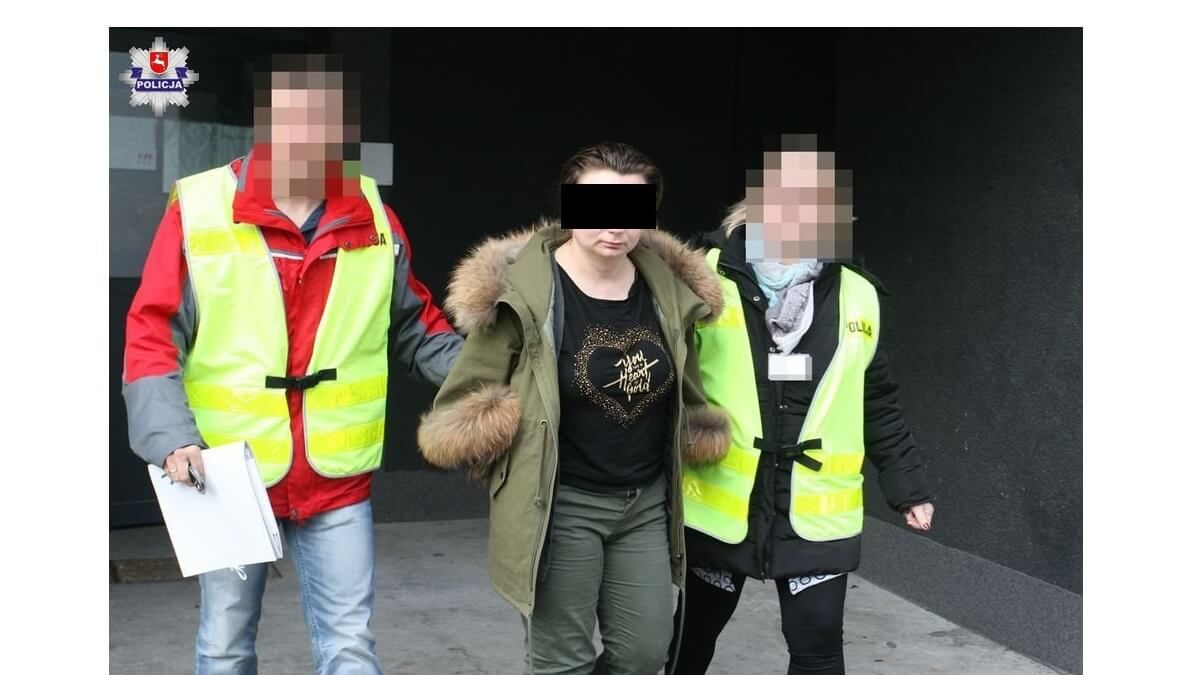 Zatrzymana kobieta prowadzona przez dwóch policjantów