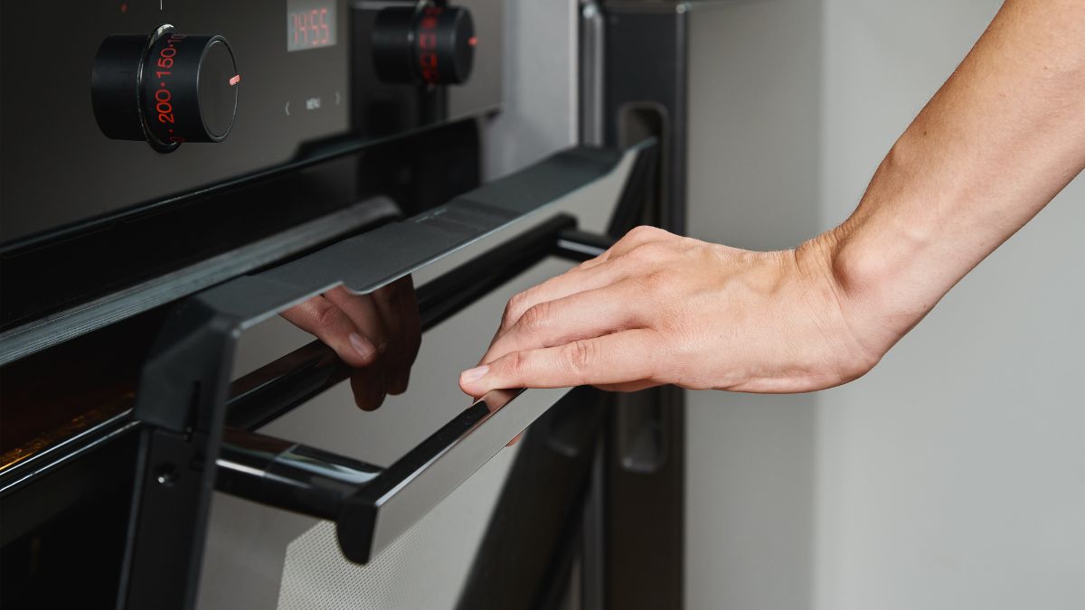 Do czego służy przycisk w drzwiach piekarnika?