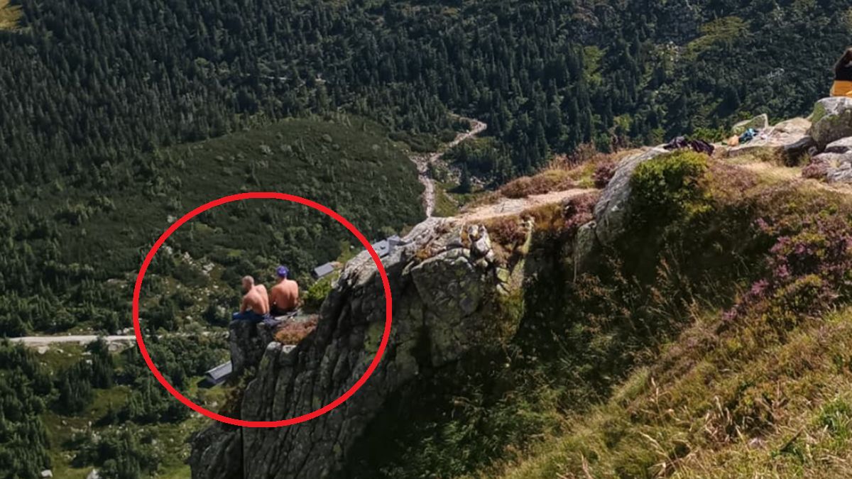 Turyści usiedli nad urwiskiem w Karkonoszach.