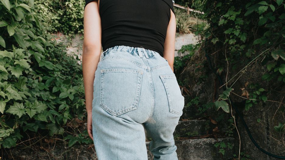 Back part of a woman wearing mom jeans surrounded by plants and modern stylemom, jeans, woman, stylish, waist, people, boyfriend, denim, garment, high, man, white, young, brother, canvas, children, close up, dad, father, hipster, kids, loss, minimal, mother, sister, stand, standing, textile, trend, wear, weight, basic, boy, comfortable, fabric, front, label, manicure, outfit, plain, rings, shirt, simple, belt, blank, body, boots, buckle, caucasian, classic, mom, jeans, woman, stylish, waist, people, boyfriend, denim, garment, high, man, white, young, brother, canvas, children, close up, dad, father, hipster, kids, loss, minimal, mother, sister, stand, standing, textile, trend, wear, weight, basic, boy, comfortable, fabric, front, label, manicure, outfit, plain, rings, shirt, simple, belt, blank, body, boots, buckle, caucasian, classic