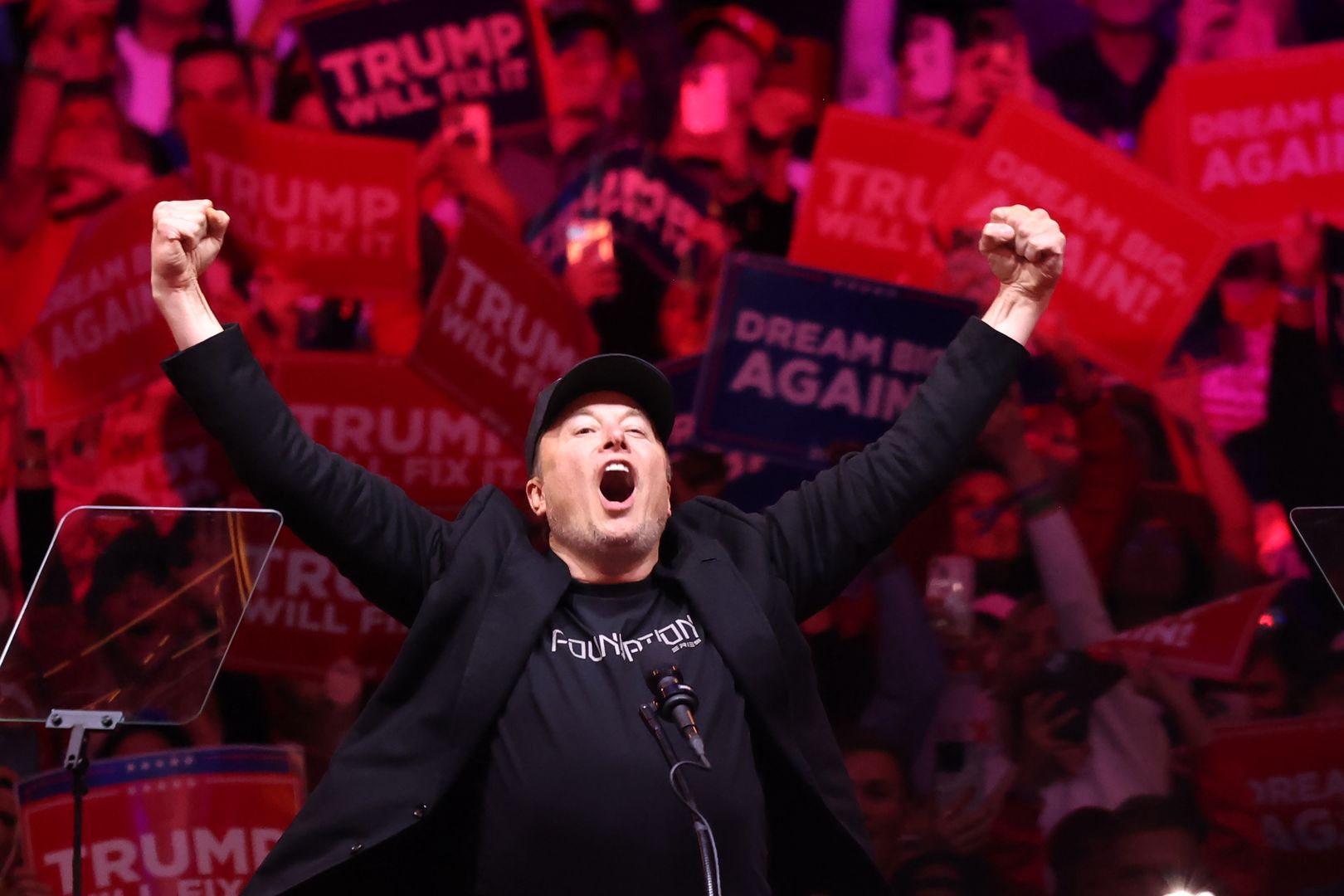 NEW YORK, NEW YORK - OCTOBER 27: Tesla and X CEO Elon Musk raises his hands as he takes the stage during a campaign rally for Republican presidential nominee, former U.S. President Donald Trump, at Madison Square Garden on October 27, 2024 in New York City. Trump closed out his weekend of campaigning in New York City with a guest list of speakers that includes his running mate Republican Vice Presidential nominee, U.S. Sen. J.D. Vance (R-OH), Tesla CEO Elon Musk, UFC CEO Dana White, and House Speaker Mike Johnson, among others, nine days before Election Day.  (Photo by Michael M. Santiago/Getty Images)