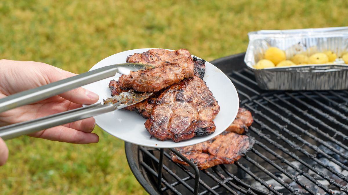 Karkówka z grilla nakładana na talerz w ogrodzie