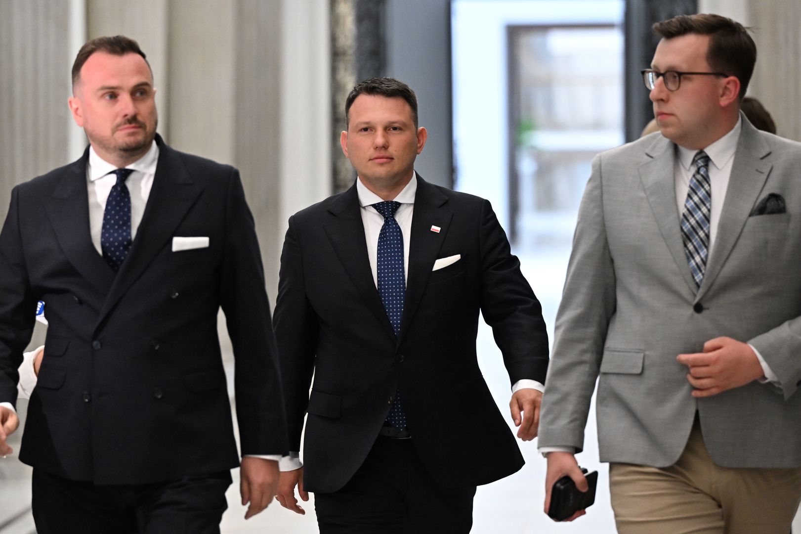 Warszawa, 20.05.2025. Wybory prezydenta RP - kampania przed II turą. Poseł Konfederacji Sławomir Mentzen (C) w drodze na konferencję prasową w Sejmie w Warszawie, 20 bm. Sławomir Mentzen zaprosił kandydata KO na prezydenta Rafała Trzaskowskiego i popieranego przez PiS Karola Nawrockiego na rozmowę oraz zaapelował o podpisanie deklaracji programowej, zgodnej z oczekiwaniami jego wyborców. (amb) PAP/Radek Pietruszka