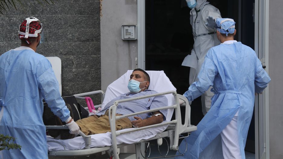 NAPLES, CAMPANIA, ITALY - 2020/11/13: Paramedicals carry a Coronavirus COVID-19 patient with a stretcher, to take him to the Antonio Cardarelli hospital ward where he will be treated. (Photo by Salvatore Laporta/KONTROLAB/LightRocket via Getty Images)