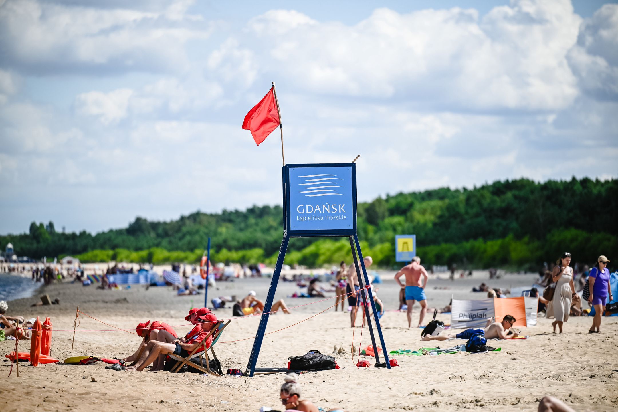 Gdańsk, 18.07.2024. Plaża w Gdańsku Jelitkowie, 18 bm. gdzie obowiązuje zakaz wchodzenia do wody. Na wszystkich sopockich i na części gdańskich kąpielisk jest zakaz kąpieli do 19 bm. Decyzja ta jest konsekwencją pożaru hali magazynowej w Gdańsku-Nowym Porcie. (aldg) PAP/Marcin Gadomski***Do tego materiału zdjęciowego dostępna jest również depesza w systemie CSI, pt.: Pomorskie/ Do piątku zakaz wchodzenia do wody na wszystkich sopockich i części gdańskich kąpielisk***